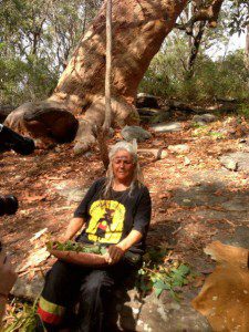 Auntie Beve, painted in ocre, at the foot of the Grandmother Tree, Bambara