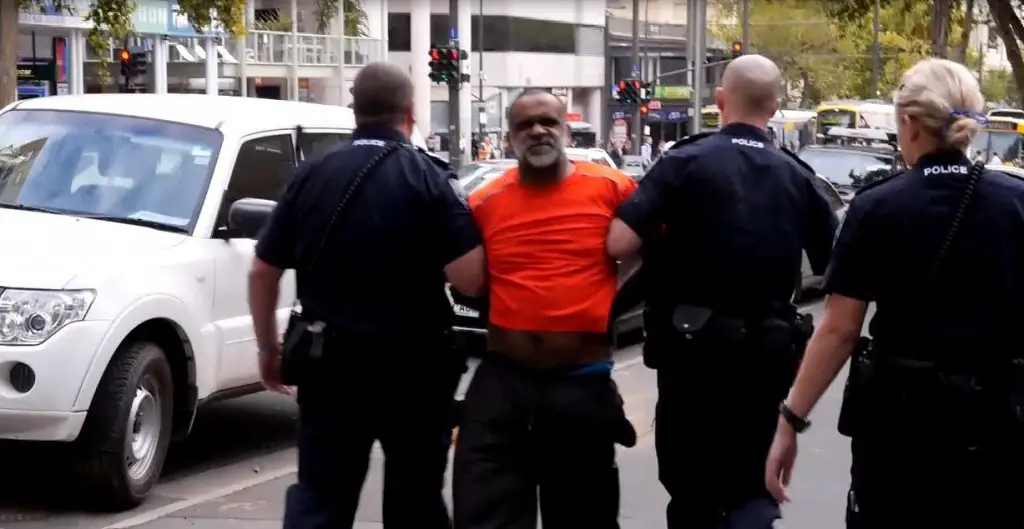Karno Walker's escorted backwards by South Australian Police